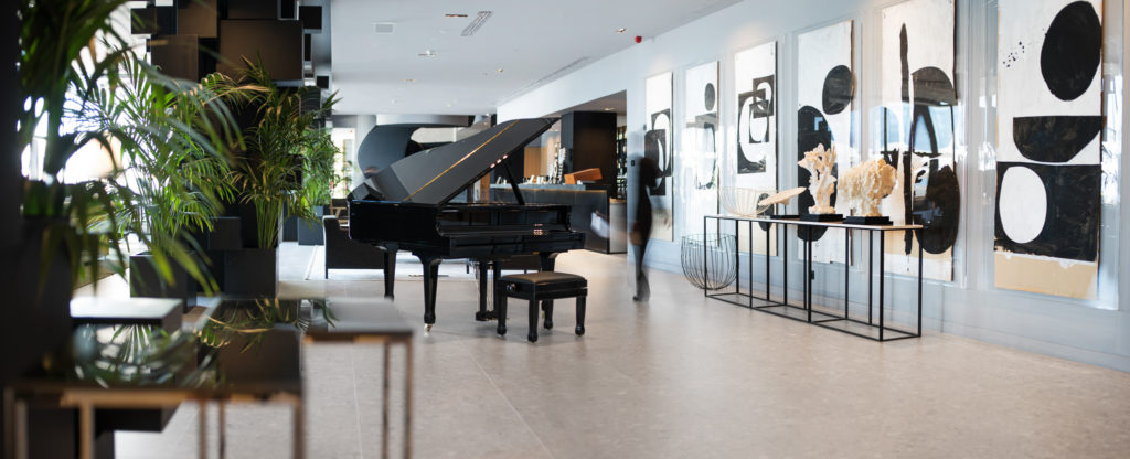 A large black piano in the center of the room at Abakus Piano Bar
