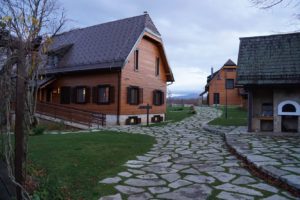 A flagstone path leads to large wooden cabins