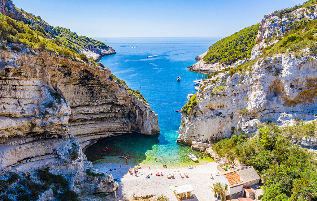 Picturesque Stiniva Bay on the island of Vis, Croatia. Remote and quiet Vis is the best place to visit in Croatia in the busy month of July, according to travel experts, Tasteful Croatian Journeys