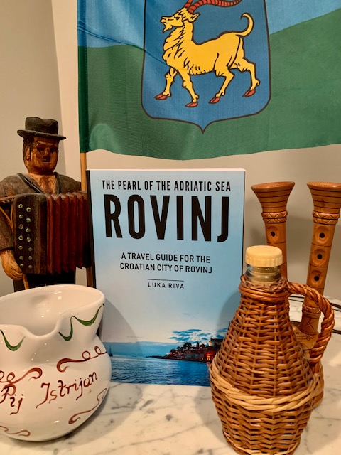 Guidebook "The Pearl of the Adriatic Sea: Rovinj, A Travel Guide for the Croatian City of Rovinj" on a table with other Croatian items