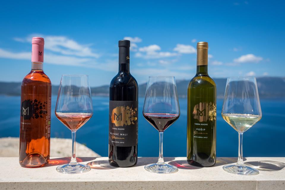 Three bottles of Croatian wine on a ledge overlooking the Adriatic sea